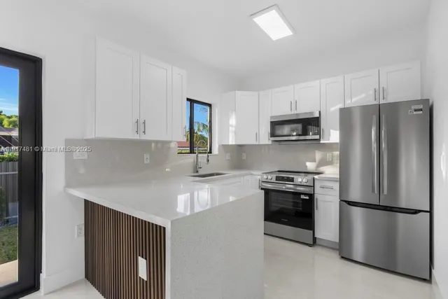 a kitchen with stainless steel appliances white cabinets and a refrigerator