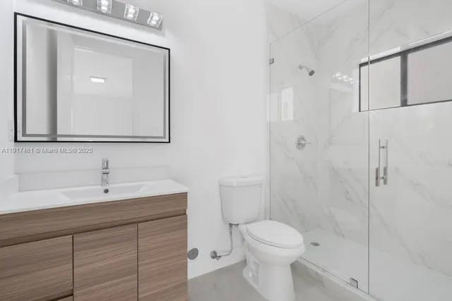 a bathroom with a toilet a sink a mirror and vanity