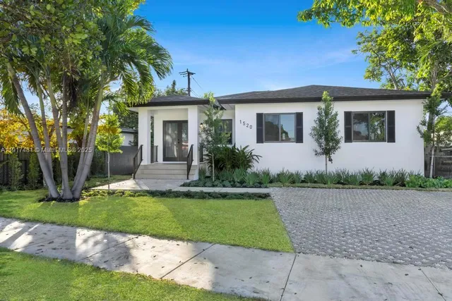 a front view of a house with a garden and yard