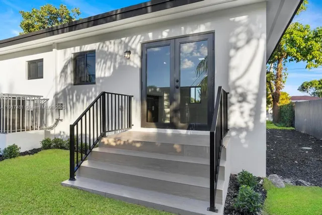 a view of a house with a small yard plants and large tree