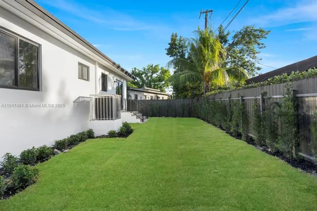 a view of a house with backyard and sitting area