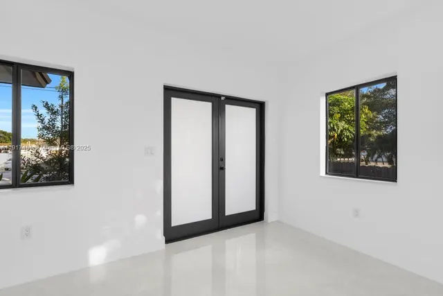 a view of an empty room with windows and closet