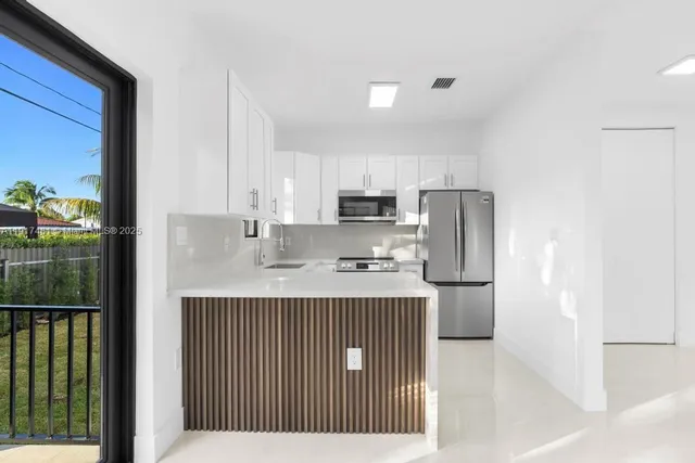 a kitchen with kitchen island a sink stainless steel appliances and cabinets