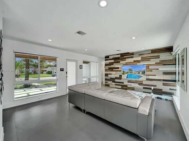 a living room with stainless steel appliances furniture and a fireplace