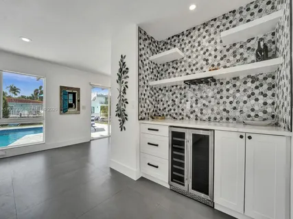 a kitchen with white cabinets and wooden floor