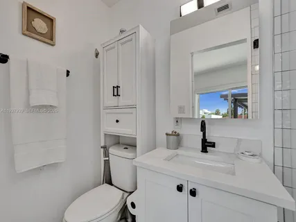 a bathroom with a sink toilet vanity and tub