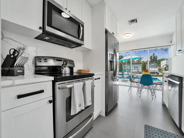 a kitchen with stainless steel appliances a stove a sink a microwave and cabinets
