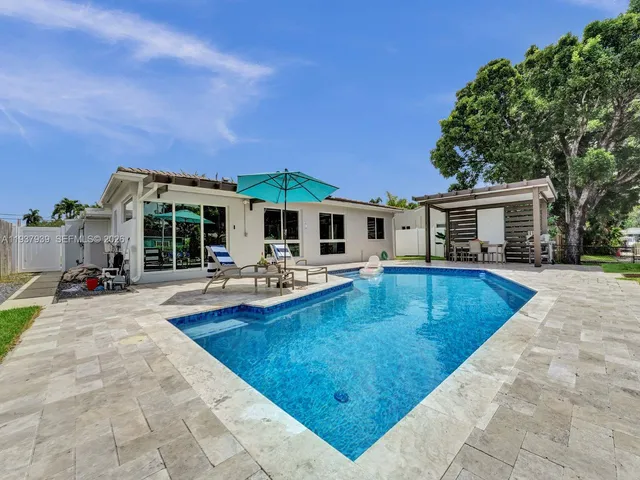 a view of a house with swimming pool and sitting area