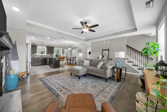 a living room with furniture and a dining table with wooden floor