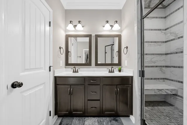 a bathroom with a granite countertop sink a large mirror and a shower