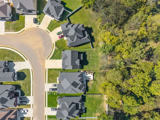 an aerial view of residential houses with outdoor space and river