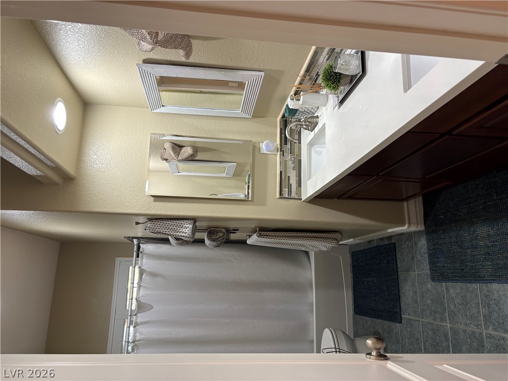 977 Rhyolite Terrace Henderson, NV 89011 - Photo 22 of 33 A classic bathroom layout includes stone counters, recessed lighting, and timeless tile flooring.