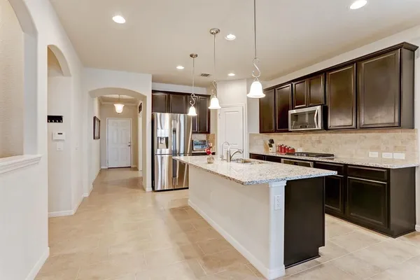 a large kitchen with stainless steel appliances and a sink