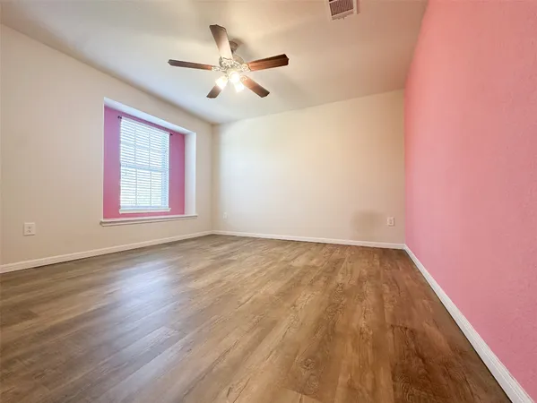 wooden floor in an empty room with a window