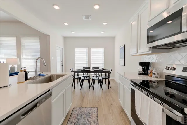 a kitchen with sink stove and cabinets
