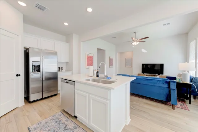 a kitchen with stainless steel appliances granite countertop a refrigerator and a stove top oven