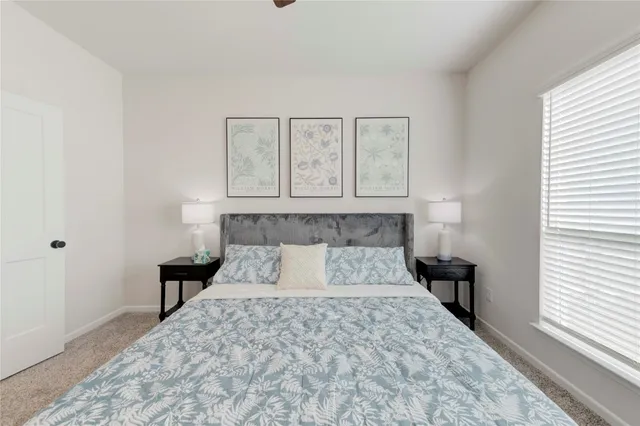 a bedroom with a large bed and wooden floor