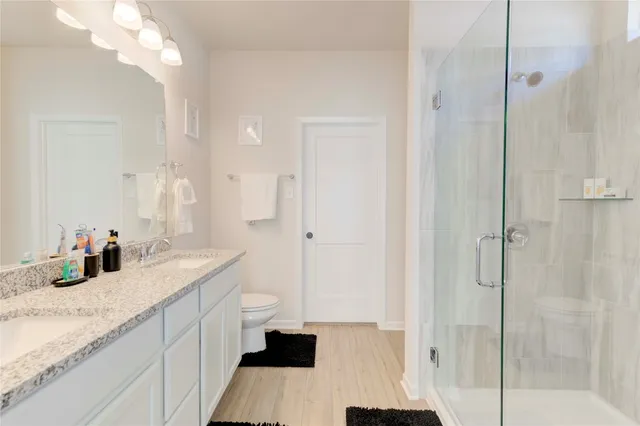 a bathroom with a granite countertop sink mirror and shower