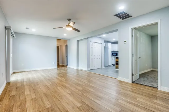 a view of empty room with wooden floor