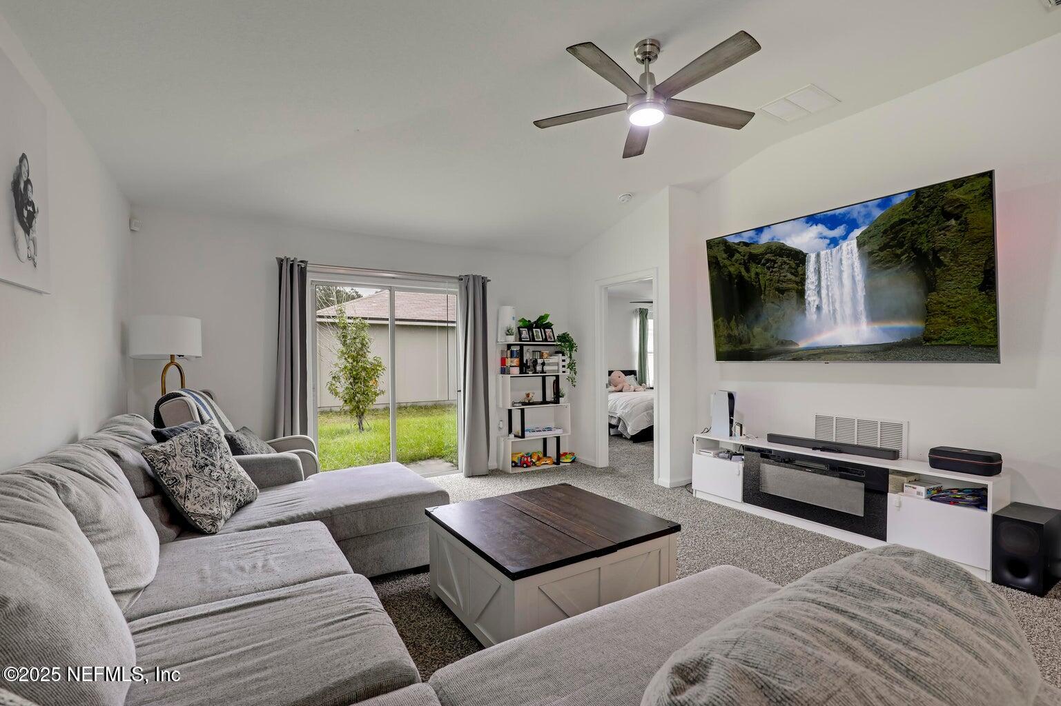 12633 Cacao Tree Trail Jacksonville, FL 32218 - Photo 24 of 44 a living room with furniture and a flat screen tv