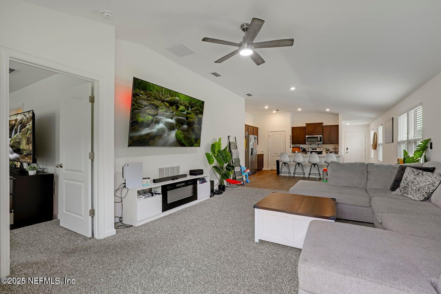 12633 Cacao Tree Trail Jacksonville, FL 32218 - Photo 25 of 44 a living room with furniture and a flat screen tv