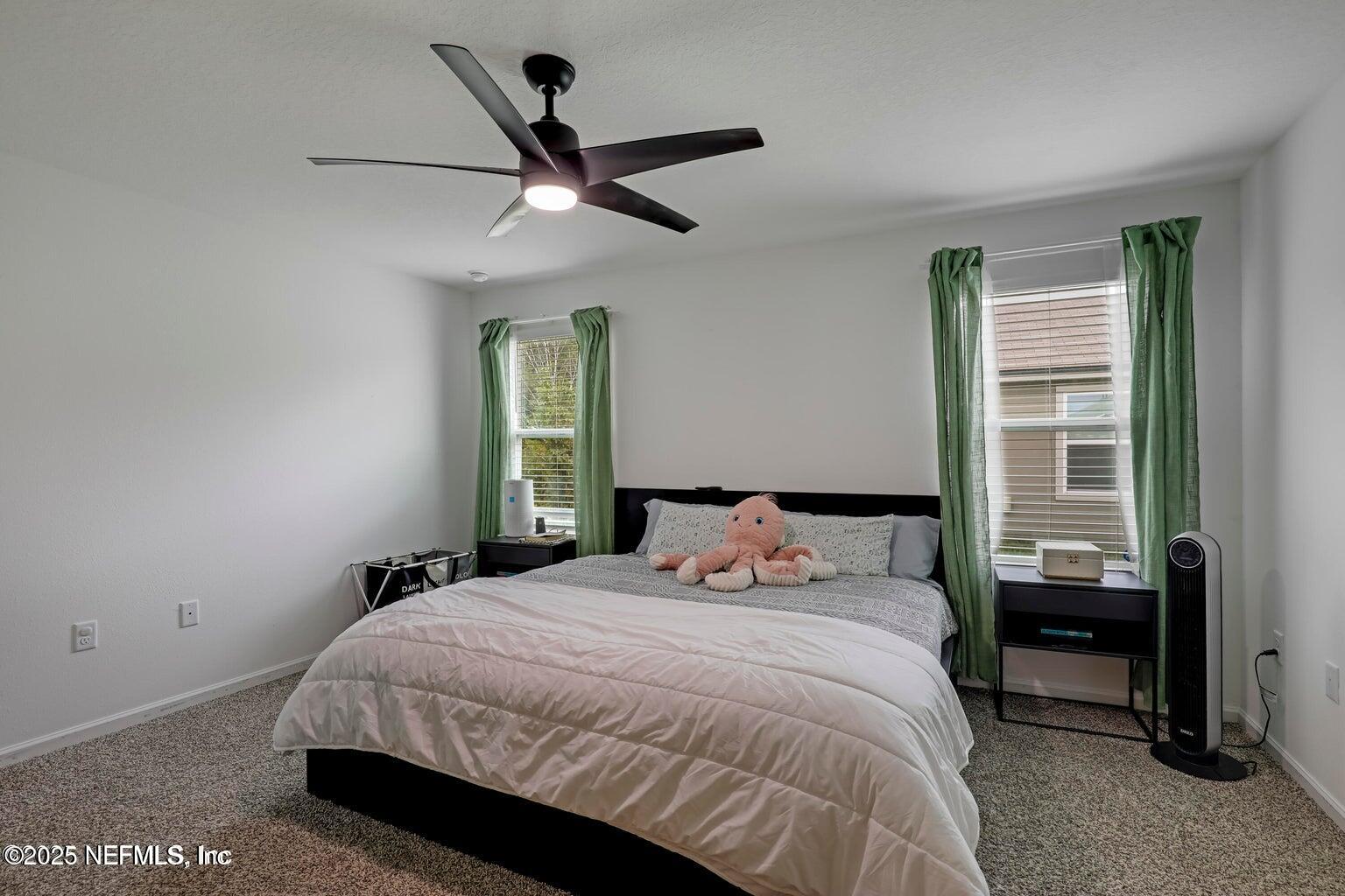 12633 Cacao Tree Trail Jacksonville, FL 32218 - Photo 27 of 44 a bedroom with a bed painted wall with a large window