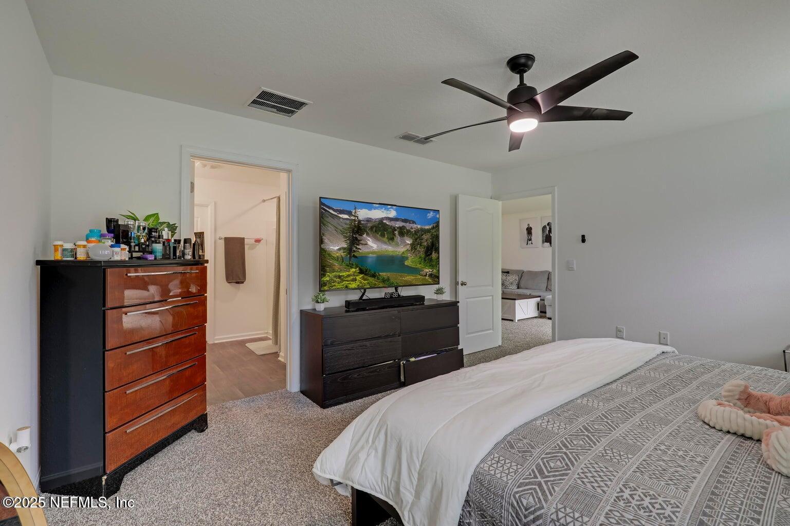 12633 Cacao Tree Trail Jacksonville, FL 32218 - Photo 28 of 44 a bedroom with a bed and a chandelier