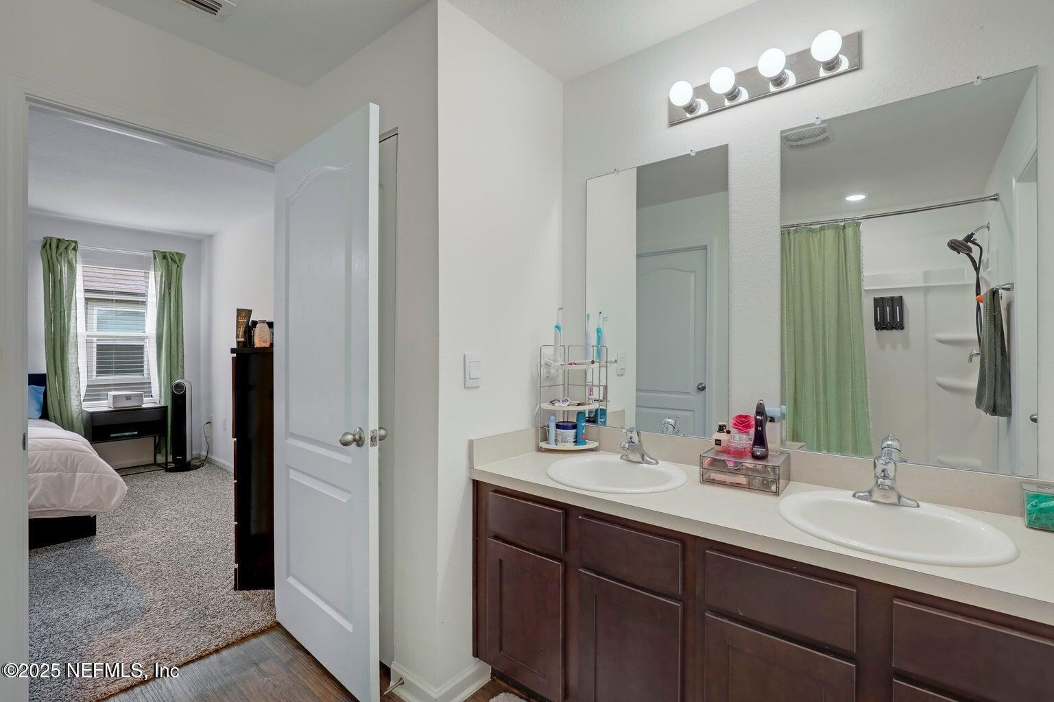 12633 Cacao Tree Trail Jacksonville, FL 32218 - Photo 31 of 44 a en suite bathroom with double sink and a mirror