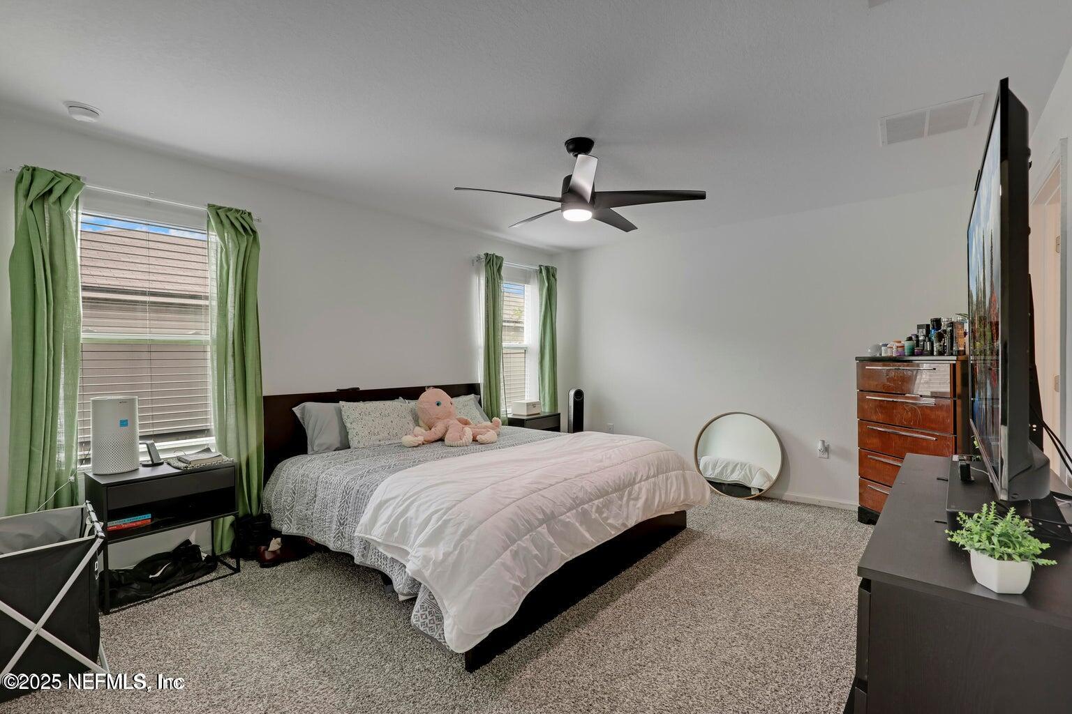 12633 Cacao Tree Trail Jacksonville, FL 32218 - Photo 5 of 44 a bedroom with a bed and a chandelier