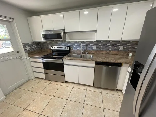 a kitchen with granite countertop a stove sink and cabinets