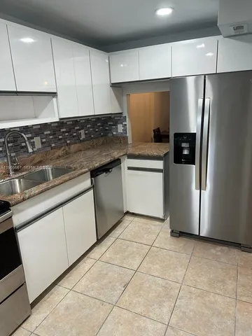 a kitchen with stainless steel appliances granite countertop a refrigerator sink and cabinets
