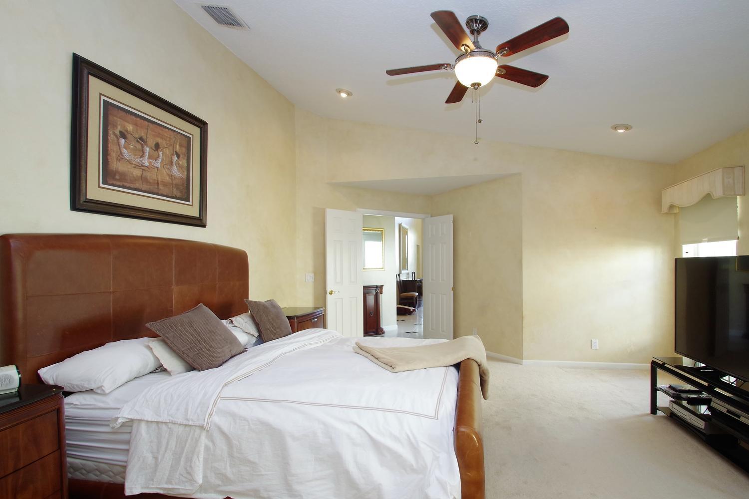 6535 Colomera Drive Boca Raton, FL 33433 - Photo 18 of 36 a bedroom with a bed and a flat screen tv