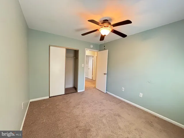 a view of an empty room with a ceiling fan