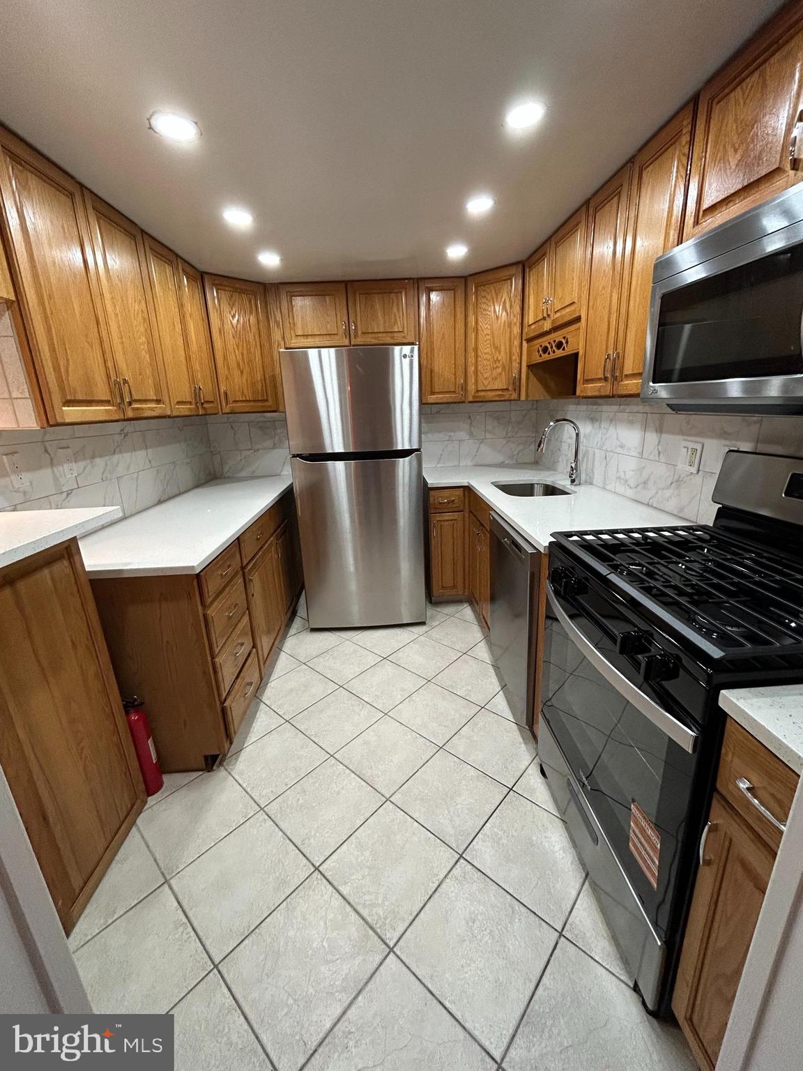 312 Old Forge Crossing, Unit 312 Devon, PA 19333 - Photo 11 of 21 a kitchen with stainless steel appliances granite countertop a stove a sink and a refrigerator
