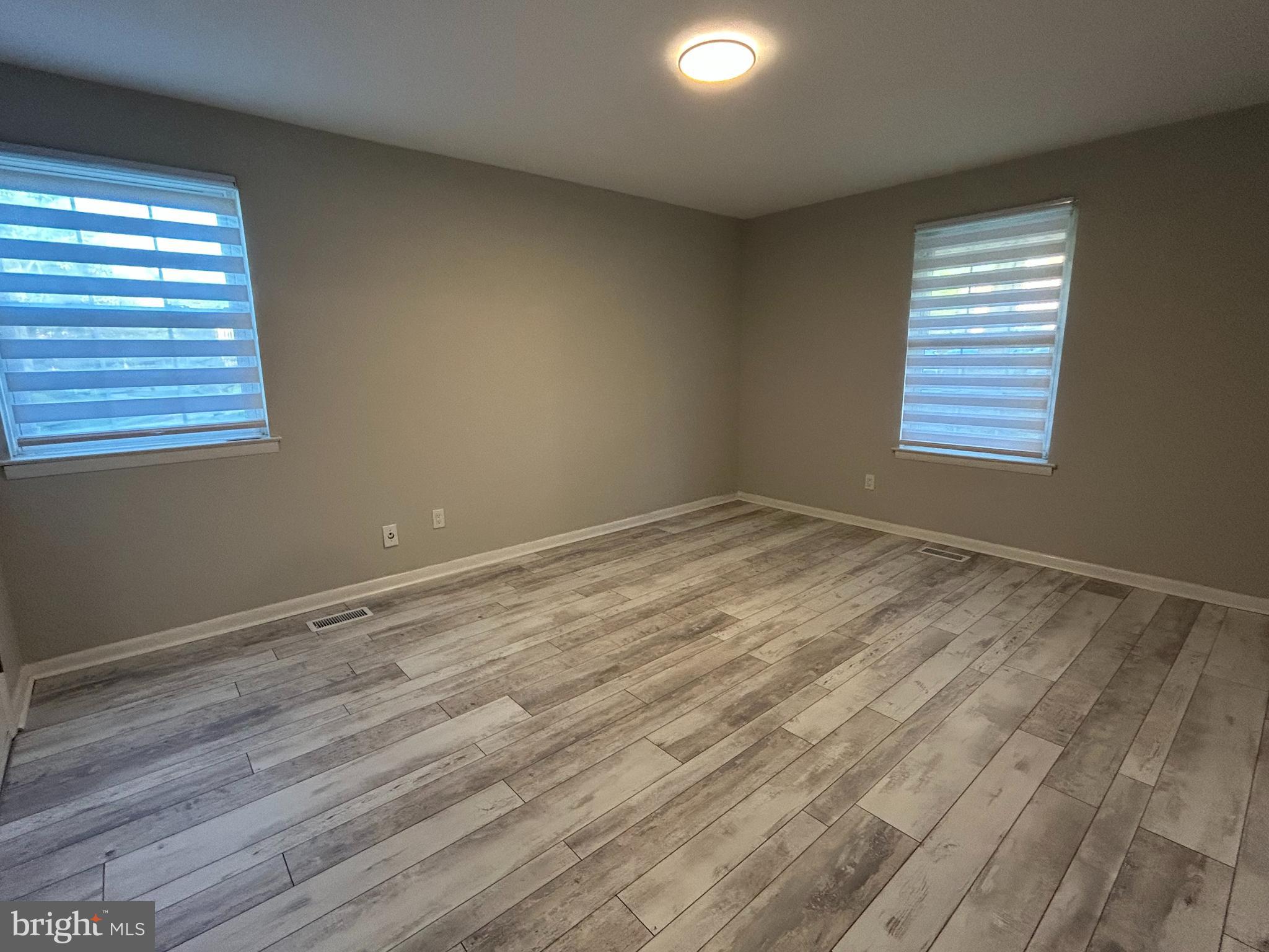 312 Old Forge Crossing, Unit 312 Devon, PA 19333 - Photo 13 of 21 wooden floor in an empty room with a window