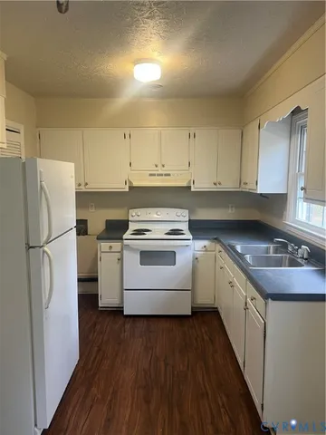a kitchen with white cabinets and white appliances
