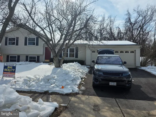 a front view of a house with cars parked