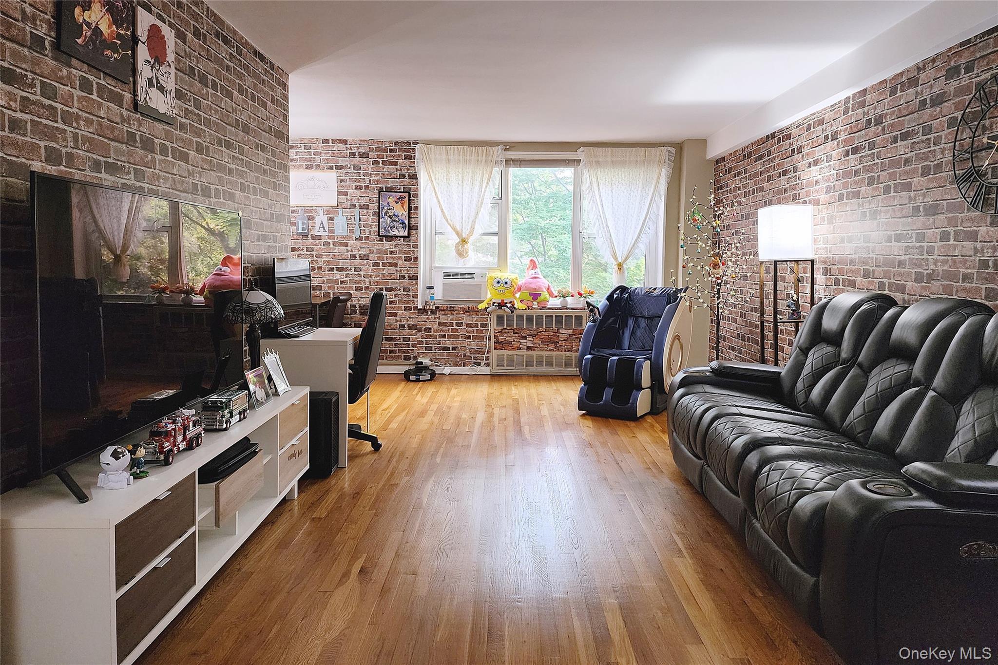 209-20 18th Avenue, Unit 5E Queens, NY 11360 - Photo 1 of 29 a living room with furniture fireplace and flat screen tv