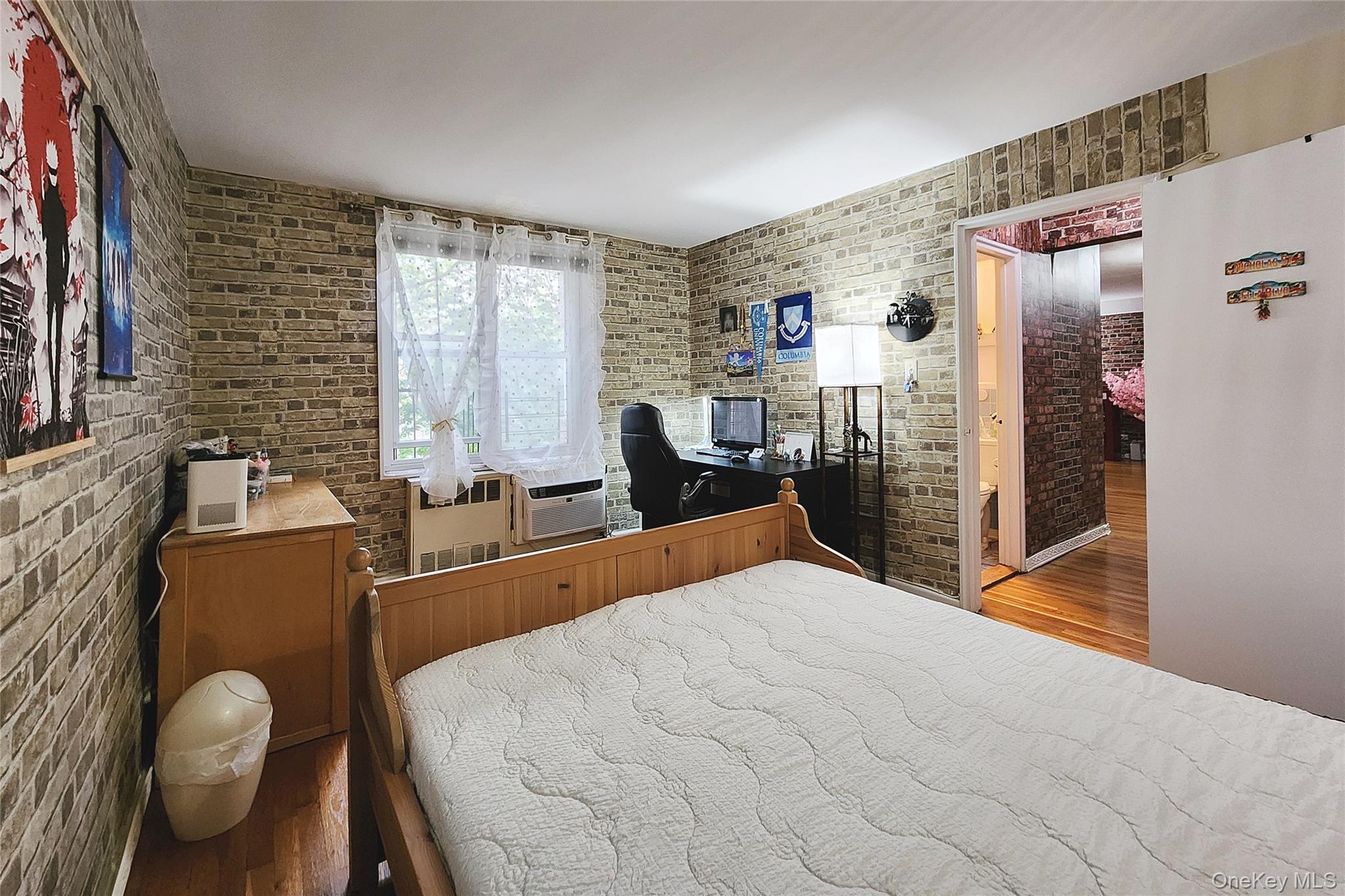 209-20 18th Avenue, Unit 5E Queens, NY 11360 - Photo 20 of 29 a bedroom with a bed and wooden floor