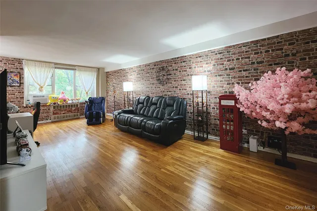 a living room with furniture a bed and wooden floor