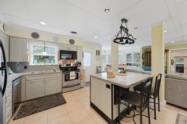 a kitchen with a sink stainless steel appliances and dining table