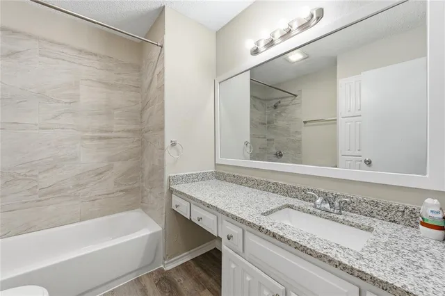 a bathroom with a granite countertop bathtub and a sink