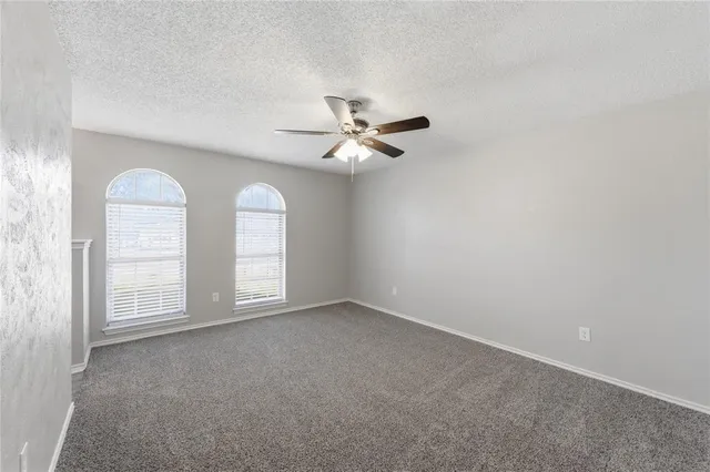 an empty room with fan and windows