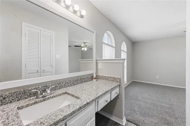 a bathroom with a granite countertop sink and a mirror