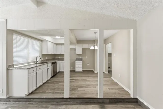 a large white kitchen with stainless steel appliances granite countertop a refrigerator and cabinets