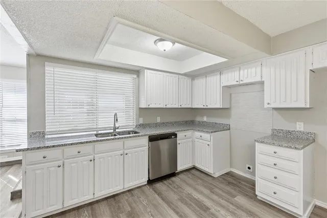 a kitchen with granite countertop white cabinets and white appliances