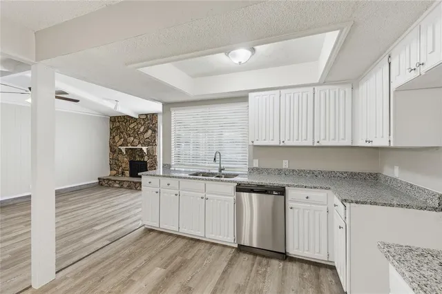 a kitchen with granite countertop a sink and cabinets