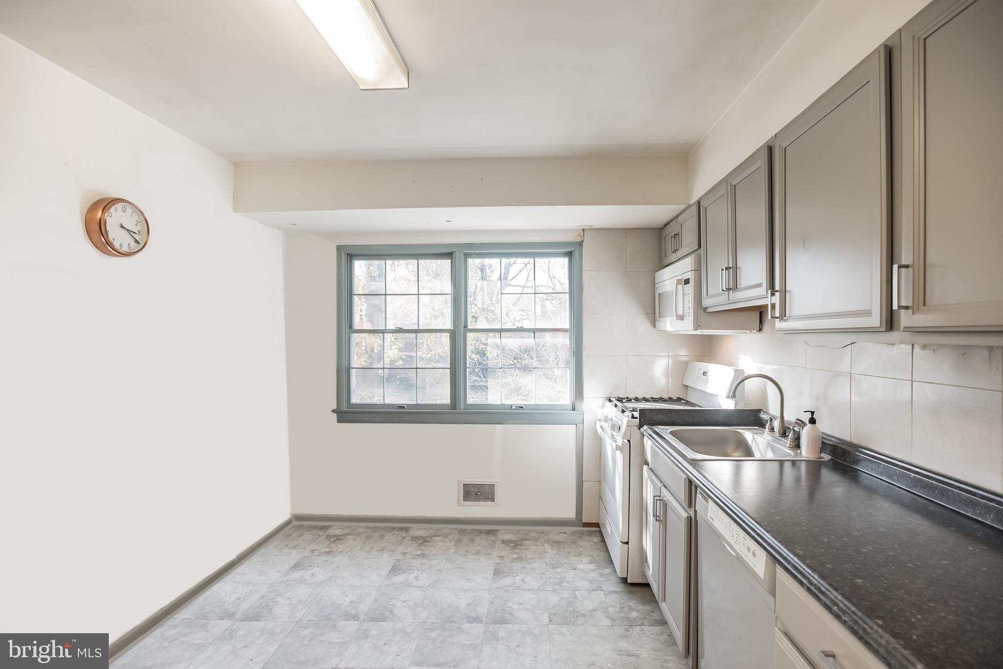 910 Woodlane Road Mount Holly, NJ 08060 - Photo 8 of 27 a kitchen that has a sink and a stove in it