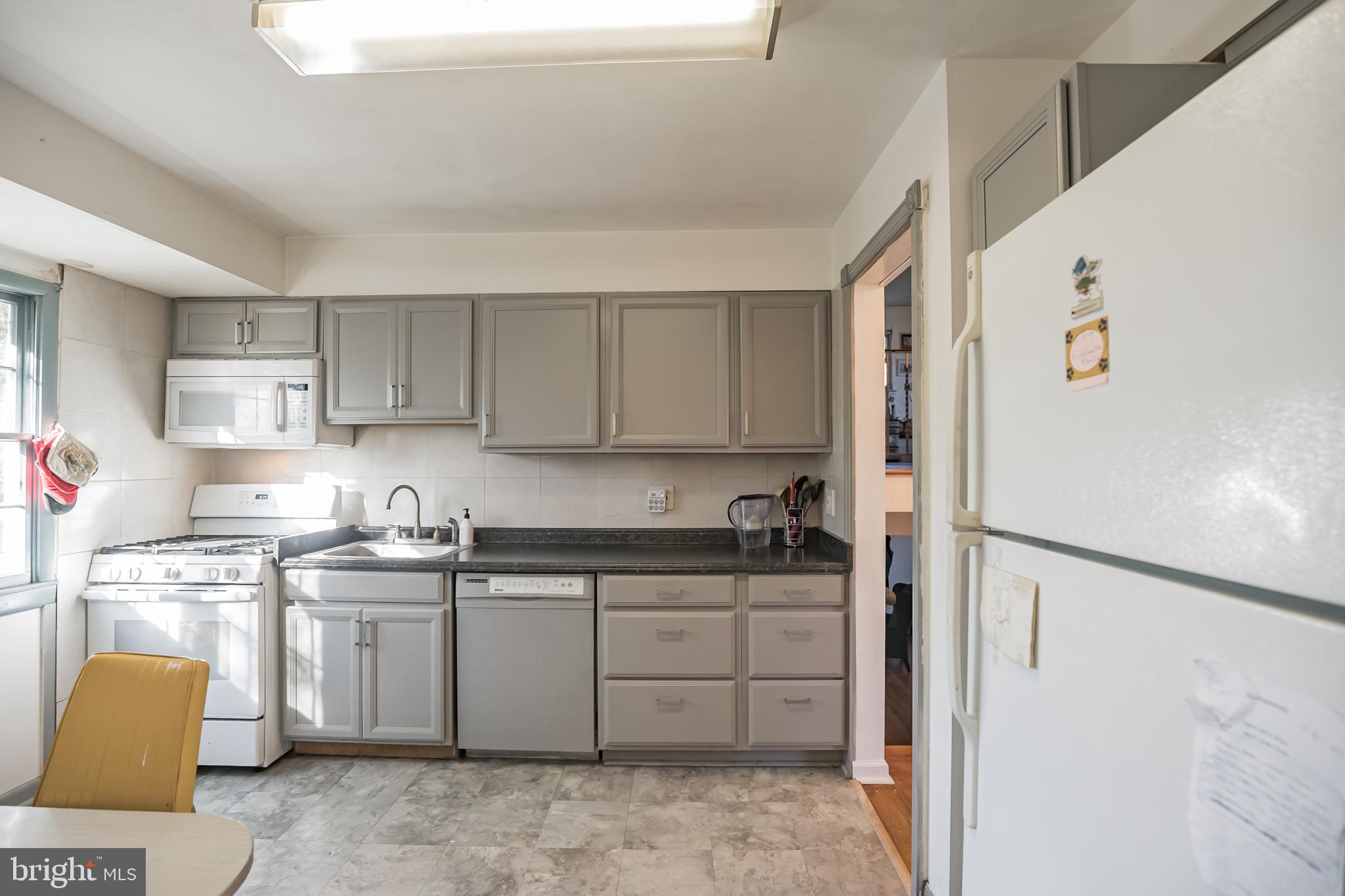 910 Woodlane Road Mount Holly, NJ 08060 - Photo 9 of 27 a kitchen with a sink a refrigerator and cabinets