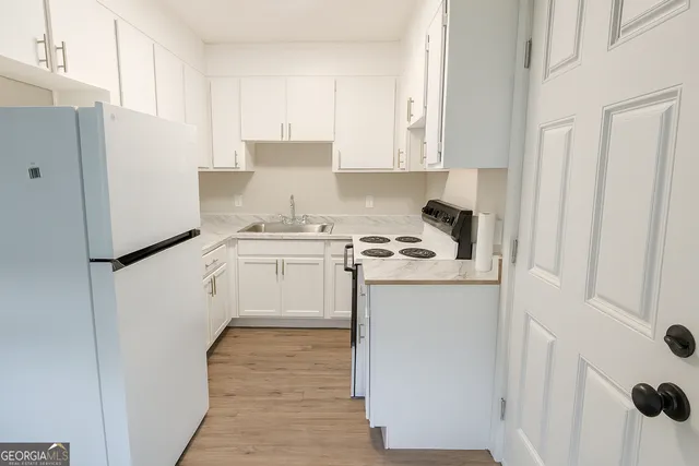 a kitchen with a white stove top oven and white cabinets